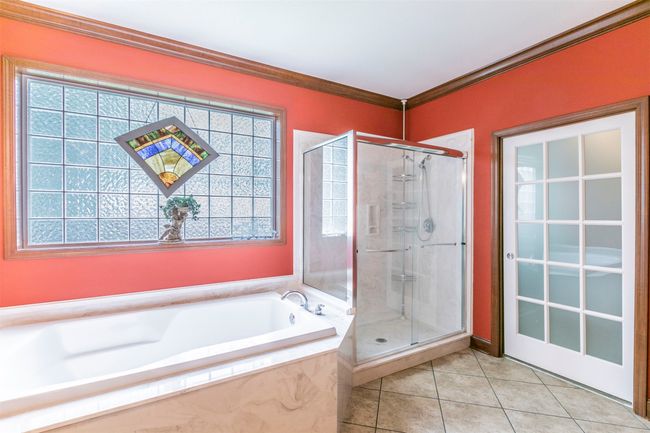 Full bathroom featuring a garden tub, tile patterned floors, a stall shower, and ornamental molding | Image 14