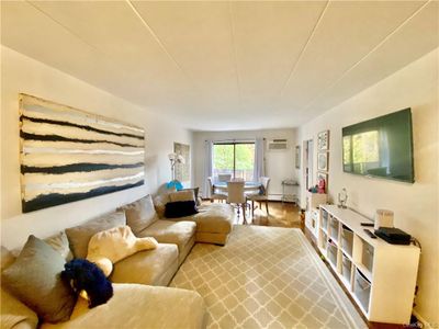 Living room with hardwood / wood-style flooring and a wall unit AC | Image 1