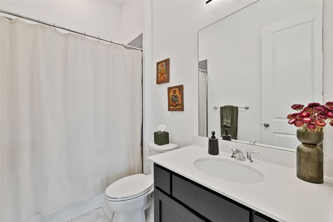 Bathroom with toilet, marble finish flooring, vanity, and a shower with shower curtain | Image 18
