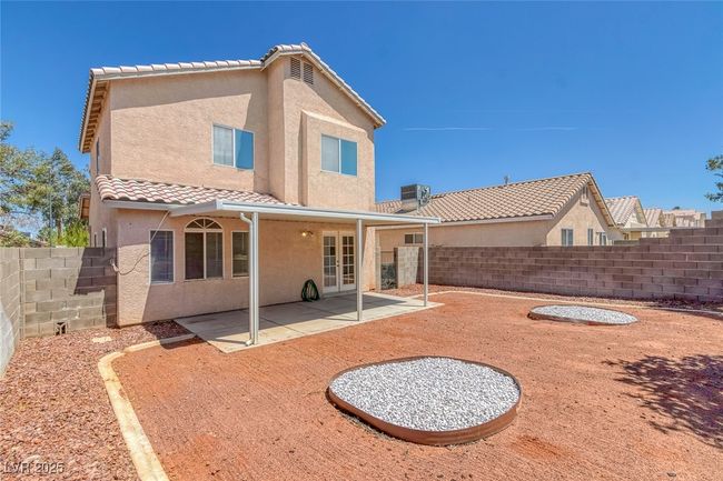 Rear view of property with stucco siding, a fenced backyard, a tile roof, and french doors | Image 29