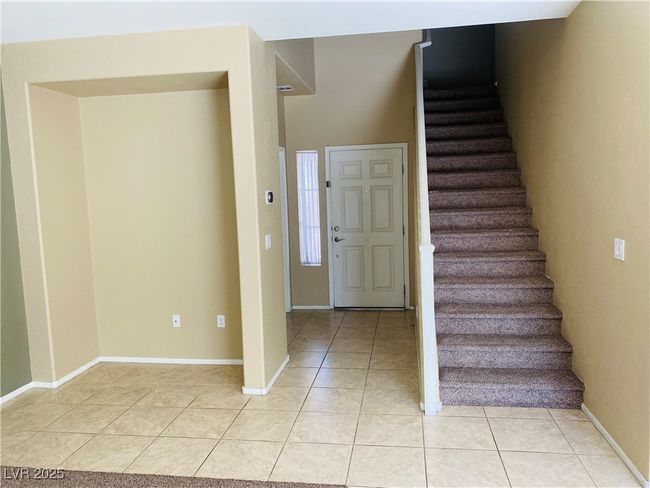 Entrance foyer featuring light tile patterned floors, baseboards, and stairs | Image 6