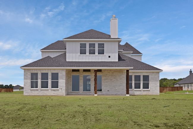 Back of house featuring a shingled roof, brick siding, board and batten siding, and a chimney | Image 38