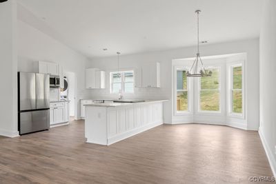 Kitchen with hardwood / wood-style floors, stainless steel appliances, decorative, white subway tile, backsplash, and white cabinetry | Image 3