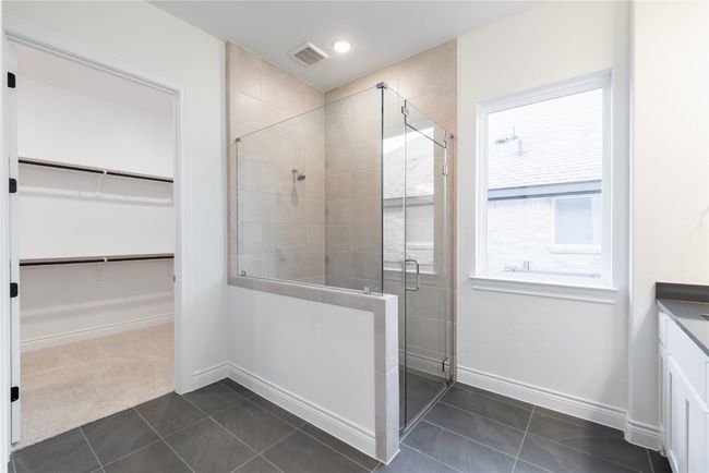 Bathroom with a spacious closet, a stall shower, tile patterned flooring, and vanity | Image 33