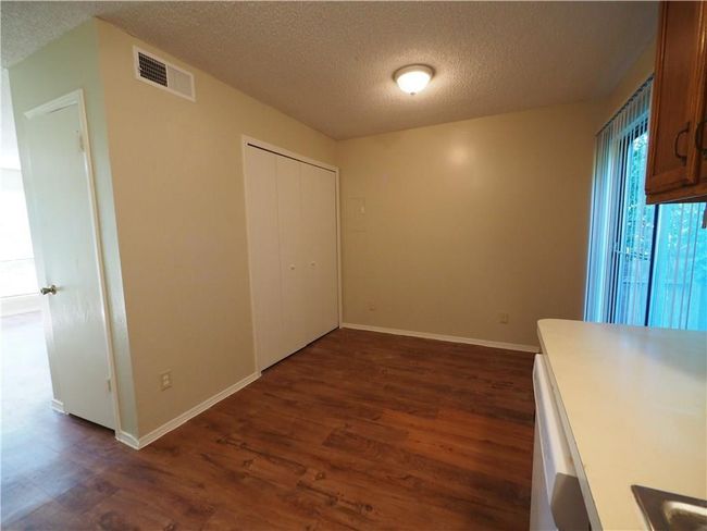 Unfurnished dining area with dark wood-style flooring, a textured ceiling, and baseboards | Image 8