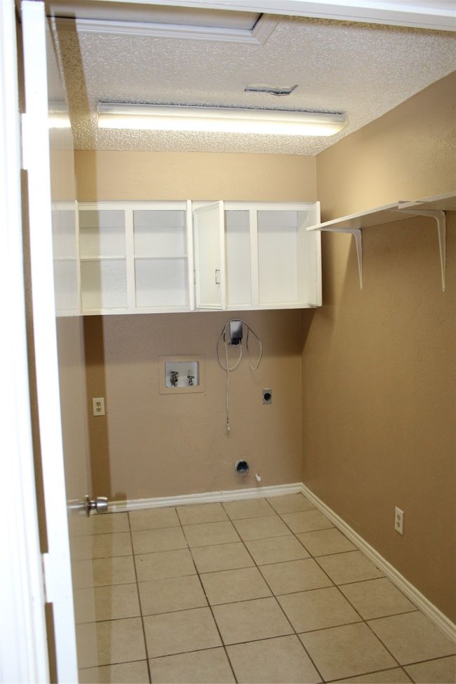 Laundry area featuring electric dryer hookup, washer hookup, light tile patterned floors, hookup for a gas dryer, and a textured ceiling | Image 13