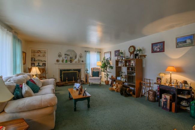 The peaceful, formal living room also has a wood-burning fireplace. | Image 4