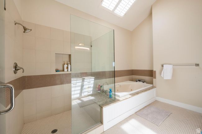 Full bathroom with tile patterned floors, vaulted ceiling, a tile shower, and a tub with jets | Image 29