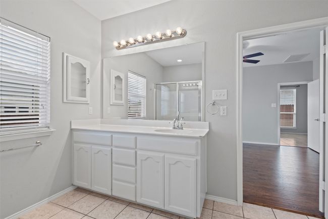 Full bath with double vanity, tile patterned flooring, and an enclosed shower | Image 16
