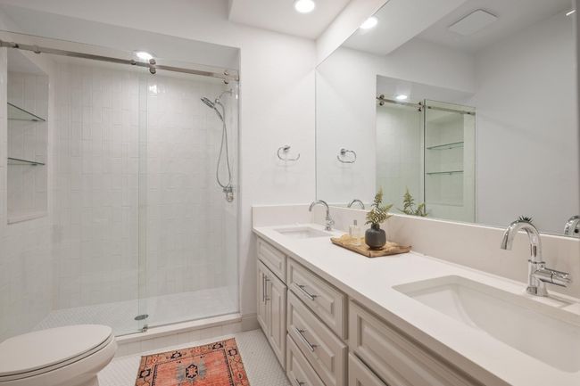 Bathroom featuring a stall shower, double vanity, recessed lighting, and tile patterned flooring | Image 22