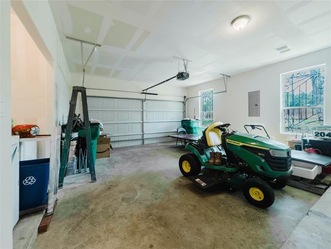 Garage featuring electric panel and a garage door opener | Image 36