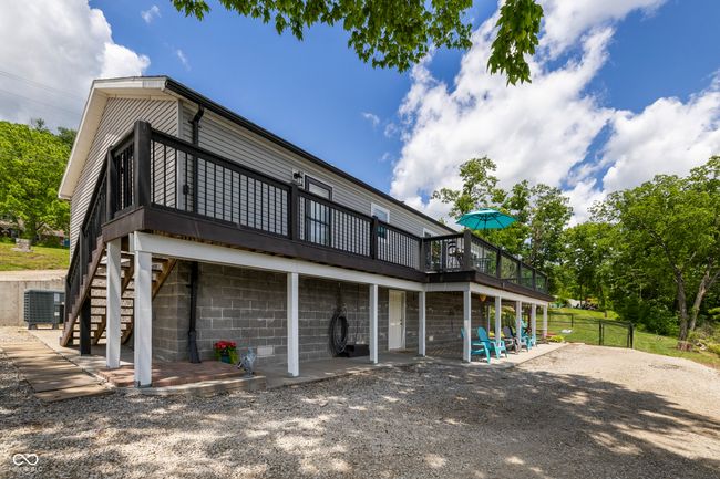 rear view of property featuring a wooden deck, cooling unit, stairway, and a patio | Image 61
