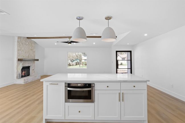 Kitchen island featuring microwave drawer and quartz countertop | Image 10