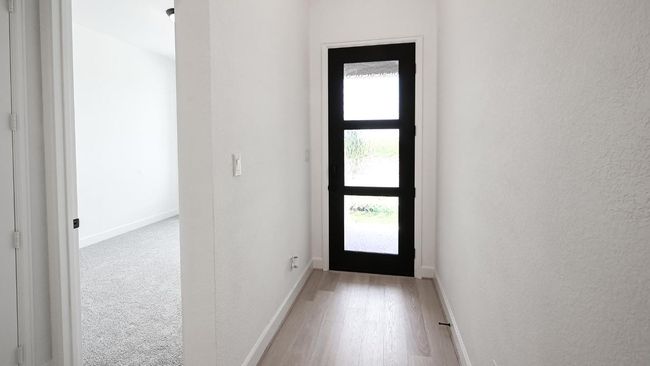Foyer featuring light wood-style floors and a textured wall | Image 14