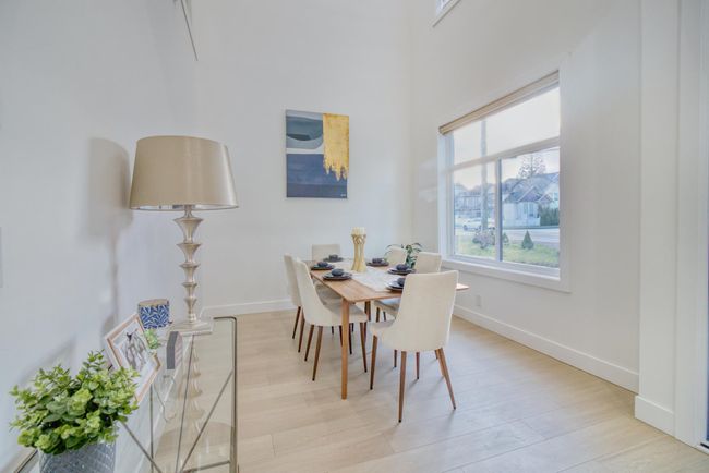 Dining area featuring baseboards, light wood-style flooring, and a high ceiling | Image 6