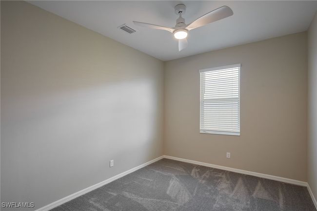 Spare room featuring carpet floors, a ceiling fan, visible vents, and baseboards | Image 14
