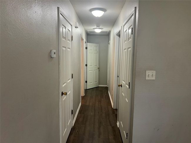 Corridor featuring dark wood-style flooring and a textured wall | Image 4