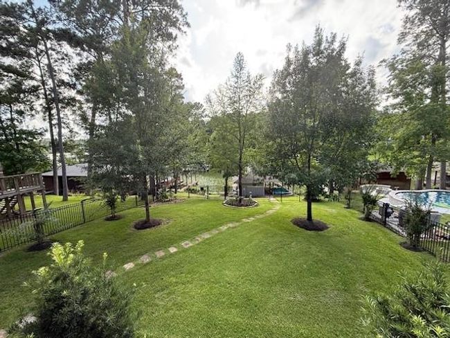 The backyard space has mature trees, stone walk-way to the boat house and a relaxing water view. | Image 37