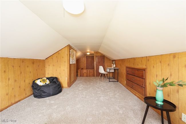 Additional living space featuring vaulted ceiling, carpet, and wooden walls | Image 30