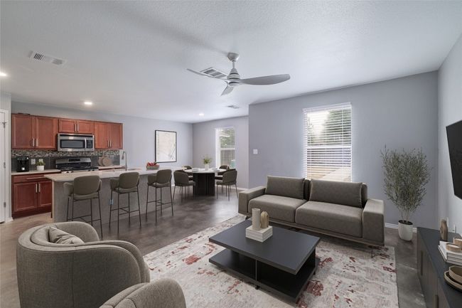 Living room with stained concrete floors, a ceiling fan, recessed lighting, and baseboards | Image 4