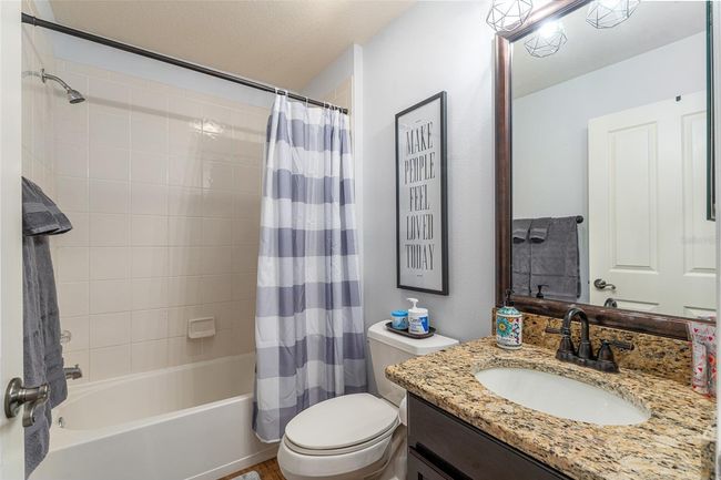 Guest bath with tub/shower combo, granite counter, upgraded lighting and mirror. | Image 22