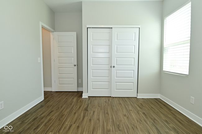 unfurnished bedroom featuring dark wood-type flooring, a closet, and baseboards | Image 19