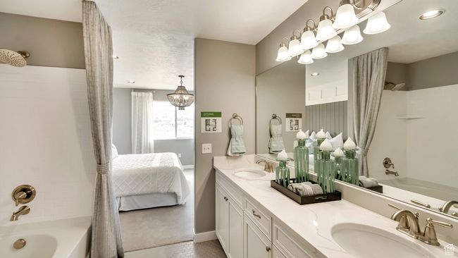 Ensuite bathroom with baseboards, shower / bath combo, double vanity, and a sink | Image 7