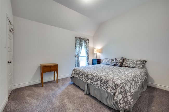 Carpeted bedroom with vaulted ceiling and baseboards | Image 21