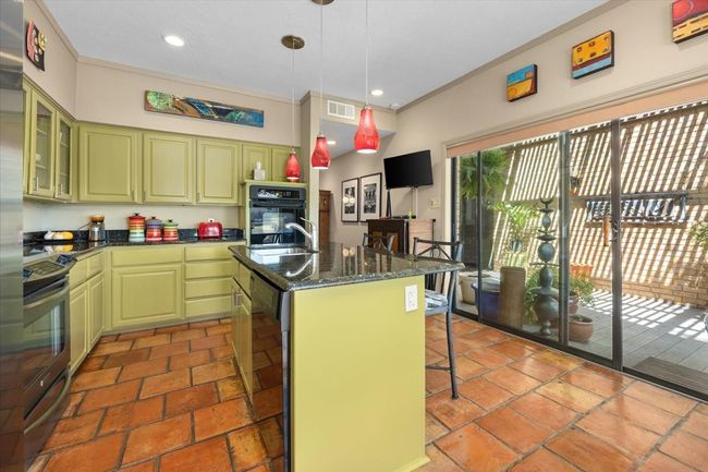Kitchen featuring a kitchen breakfast bar, visible vents, black oven, stainless steel electric range, and green painted cabinetry | Image 21