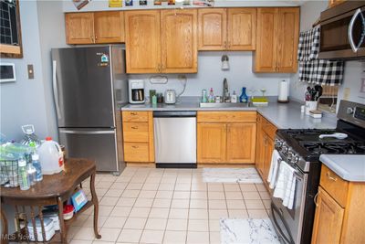 Kitchen featuring sink, appliances with stainless steel finishes, and light tile patterned floors | Image 3