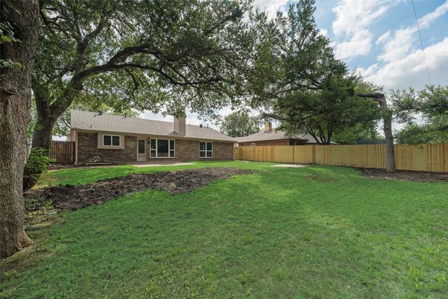 Rear view of property with brick siding, a chimney, and a patio | Image 21