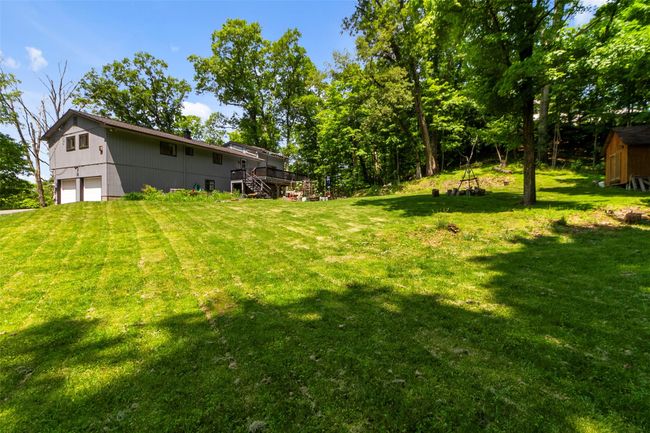 View of green lawn featuring stairs, a wooden deck, a shed, and a detached garage | Image 20