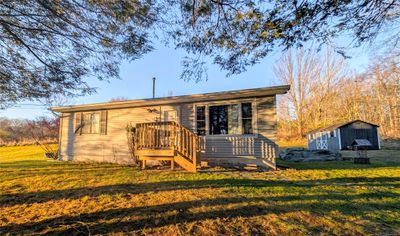 Rear view of house featuring a yard and a shed | Image 1