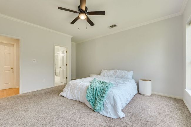 Bedroom with ornamental molding, carpet floors, ceiling fan, and connected bathroom | Image 19