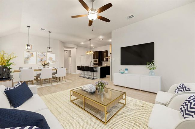 This living room is more like a GREAT room featuring a stunning fireplace with mantel detailing, custom paint, soaring high ceiling, recessed lighting, dark stained ceiling fan, and an amazing wall of windows providing a lovely view of your backyard to keep an eye out on the kids or pets playing. *Virtually Staged | Image 7
