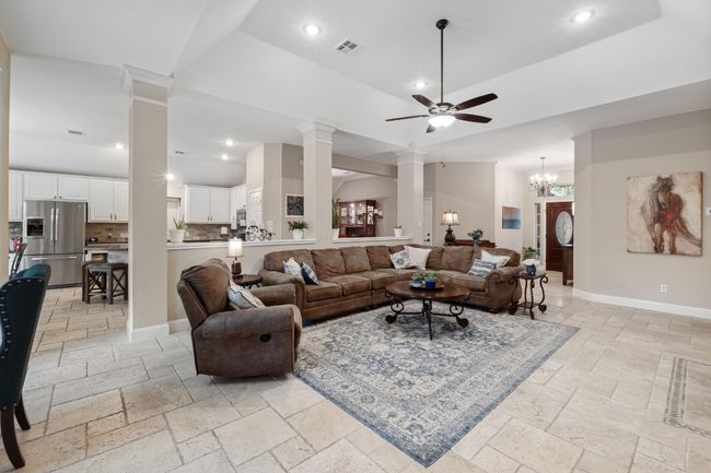 Great room featuring stone tile floors, built in shelves, fireplace, and recessed lighting | Image 9