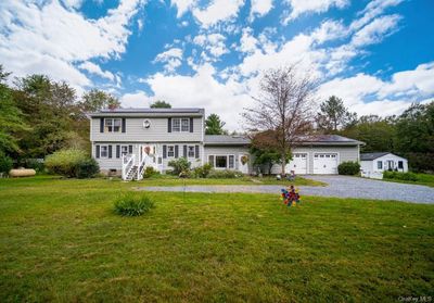 Colonial inspired home with a garage and a front yard | Image 1