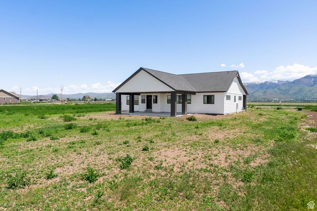 Modern inspired farmhouse featuring a mountain view, a patio, a view of countryside, and a shingled roof | Image 19