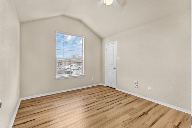 Empty room with light wood-type flooring, a ceiling fan, and vaulted ceiling | Image 30