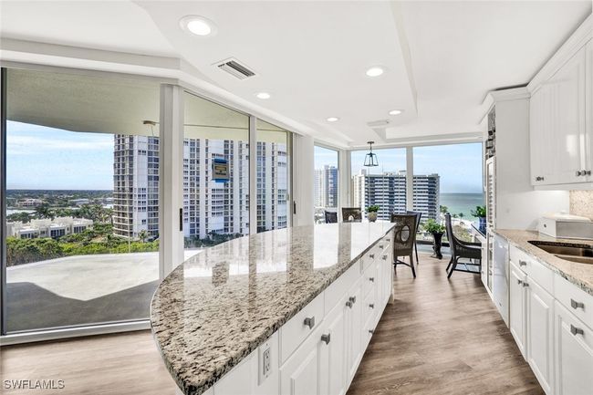 Kitchen featuring a sink, expansive windows, white cabinets, visible vents, and recessed lighting | Image 16