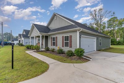 View of front of property featuring a front lawn, covered porch, and a garage | Image 3