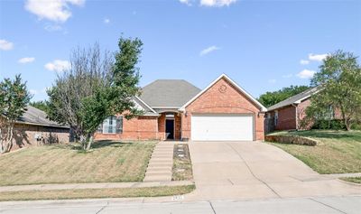 Ranch-style house featuring a front yard and a garage | Image 1