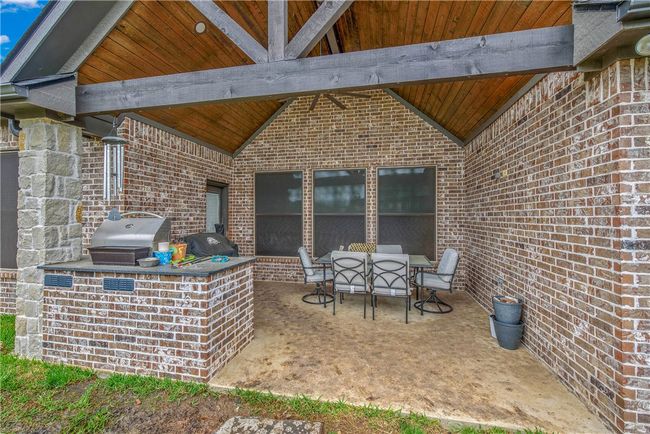 View of patio with outdoor dining space, a grill | Image 25