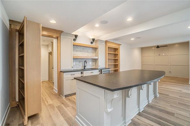 Kitchen with a sink, dark countertops, open shelves, light wood finished floors, and recessed lighting | Image 44