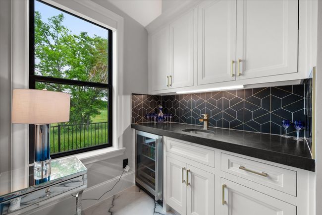 Bar with a sink, decorative backsplash, indoor wet bar, and beverage cooler | Image 19