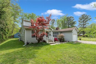 This property has a charming exterior with curb appeal. The blue storage shed is nestled in the backyard. See yourself creating memories in a place you can proudly call home. | Image 1