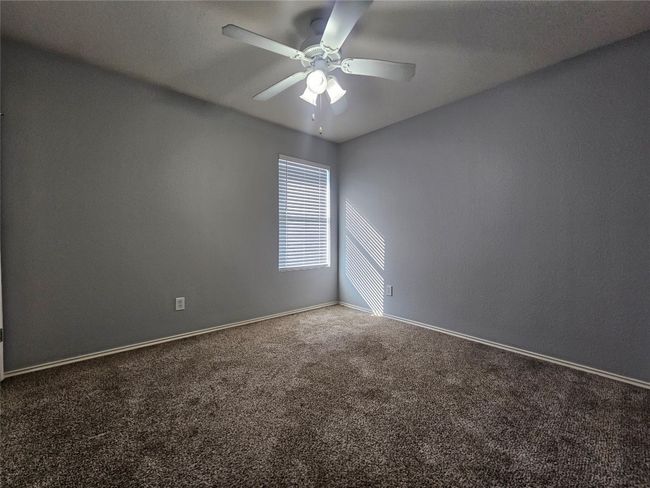 Carpeted empty room with a ceiling fan and baseboards | Image 25