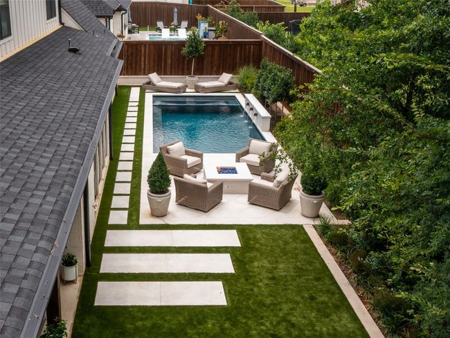 View of swimming pool with an outdoor living space with a fire pit, a fenced backyard, and a patio | Image 32