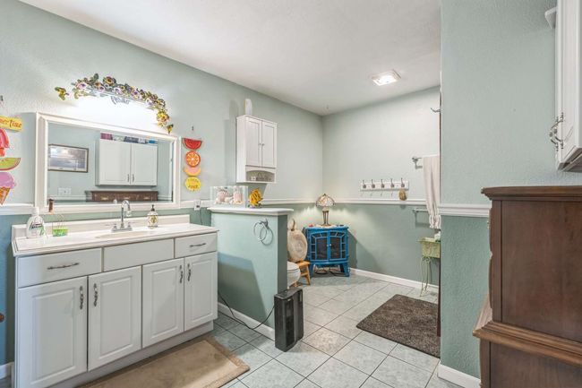 Bathroom with vanity, tile patterned floors, a wood stove, and baseboards | Image 41