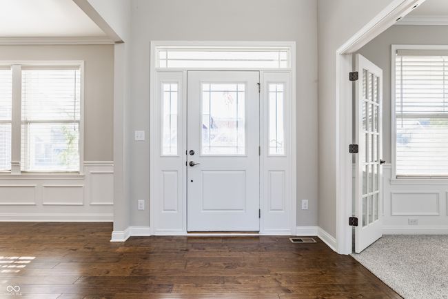 foyer featuring baseboards, ornamental molding, dark wood-type flooring, and visible vents | Image 5